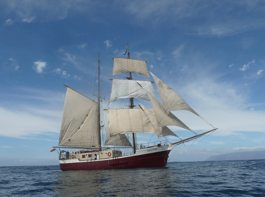 A tall ship with open sails in the water